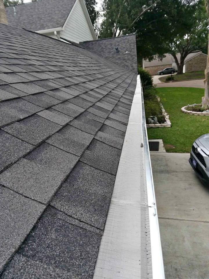 Cleaned gutter face along the roof edge of a shingle roof