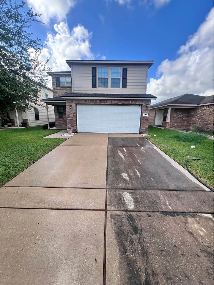 Before and after driveway pressure washing showing dirty and clean concrete halves